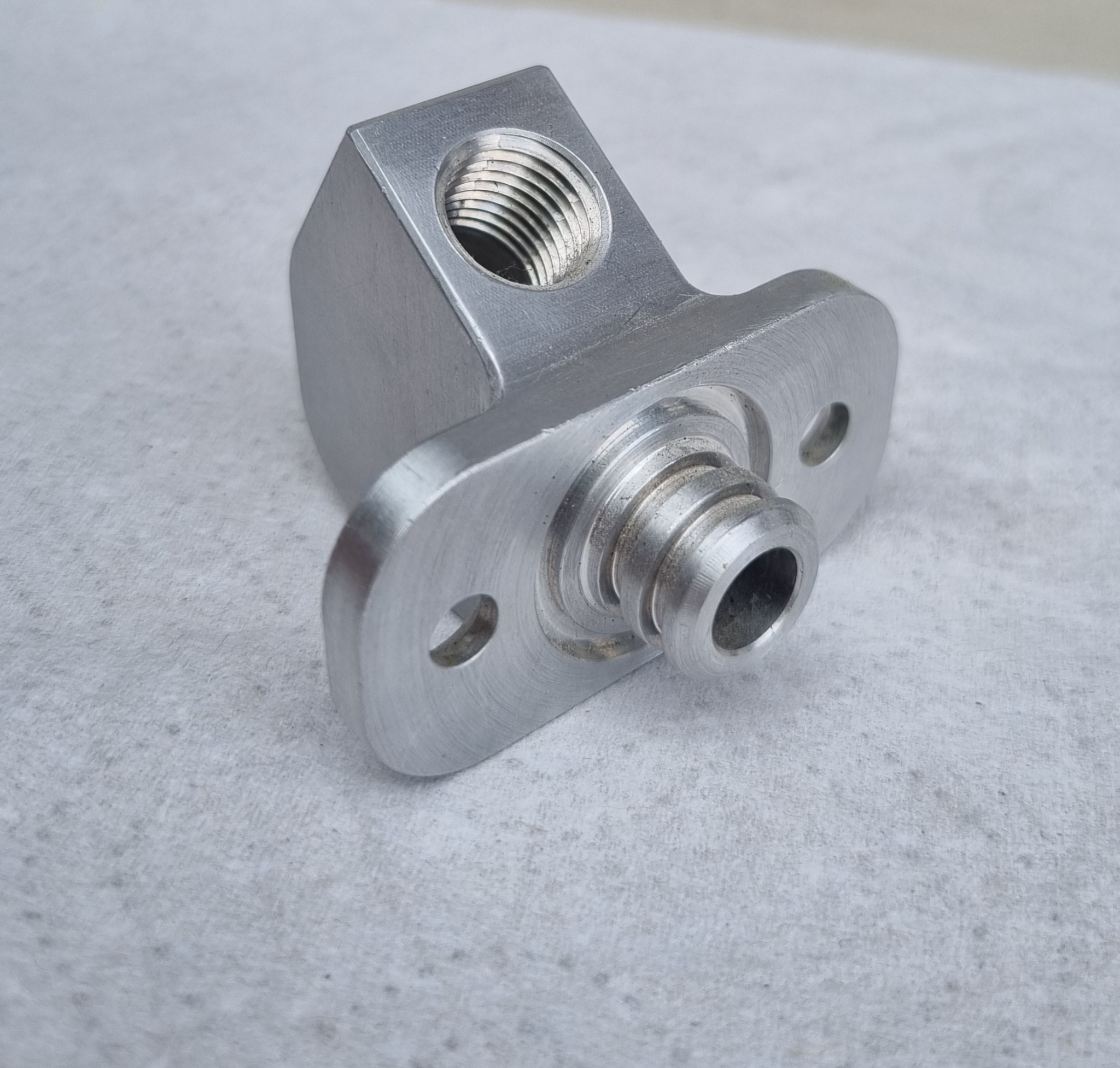 Small machined fitting with threaded opening and turned features