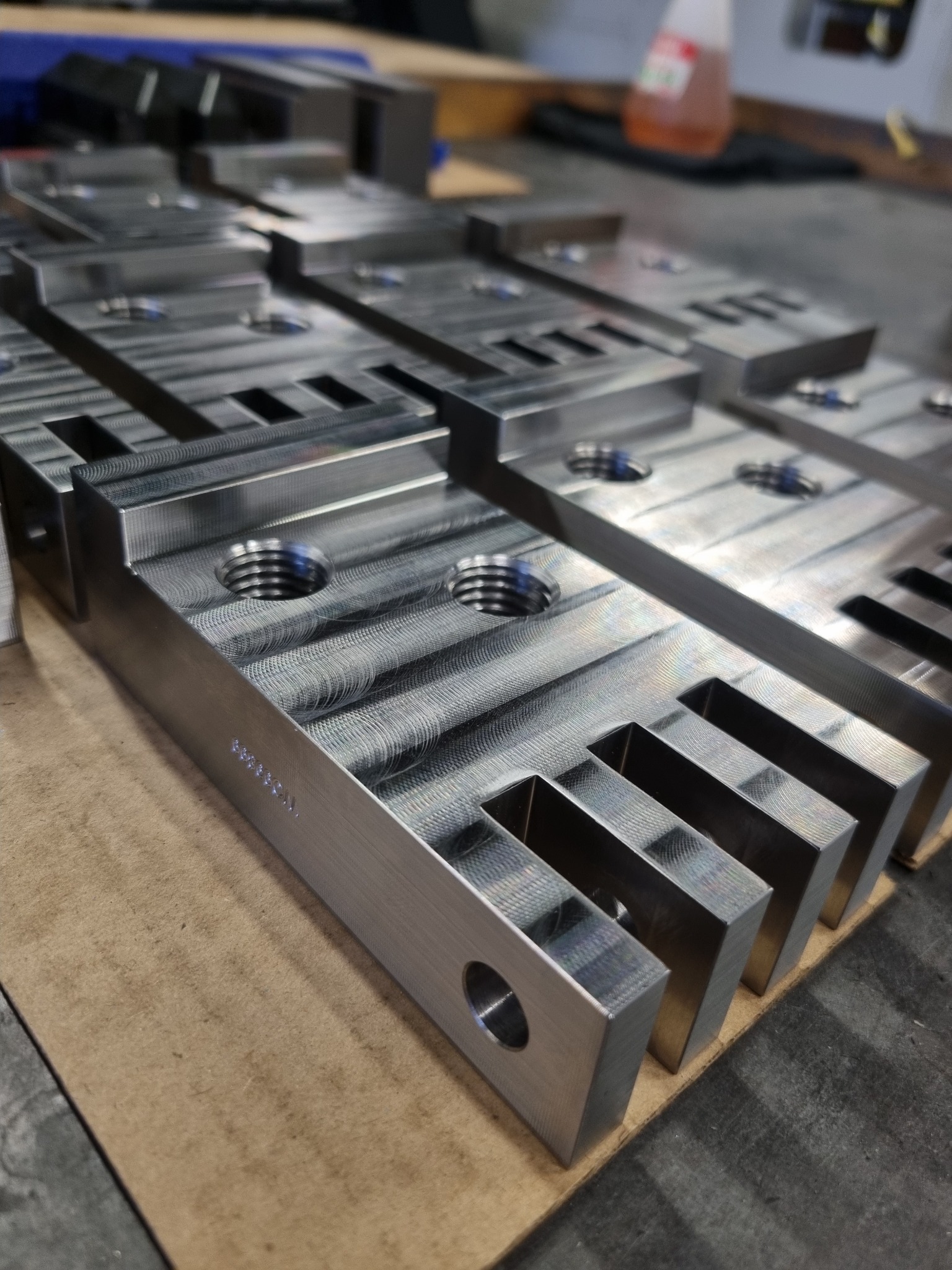 Precision machined aluminium components showing surface finish and slot features