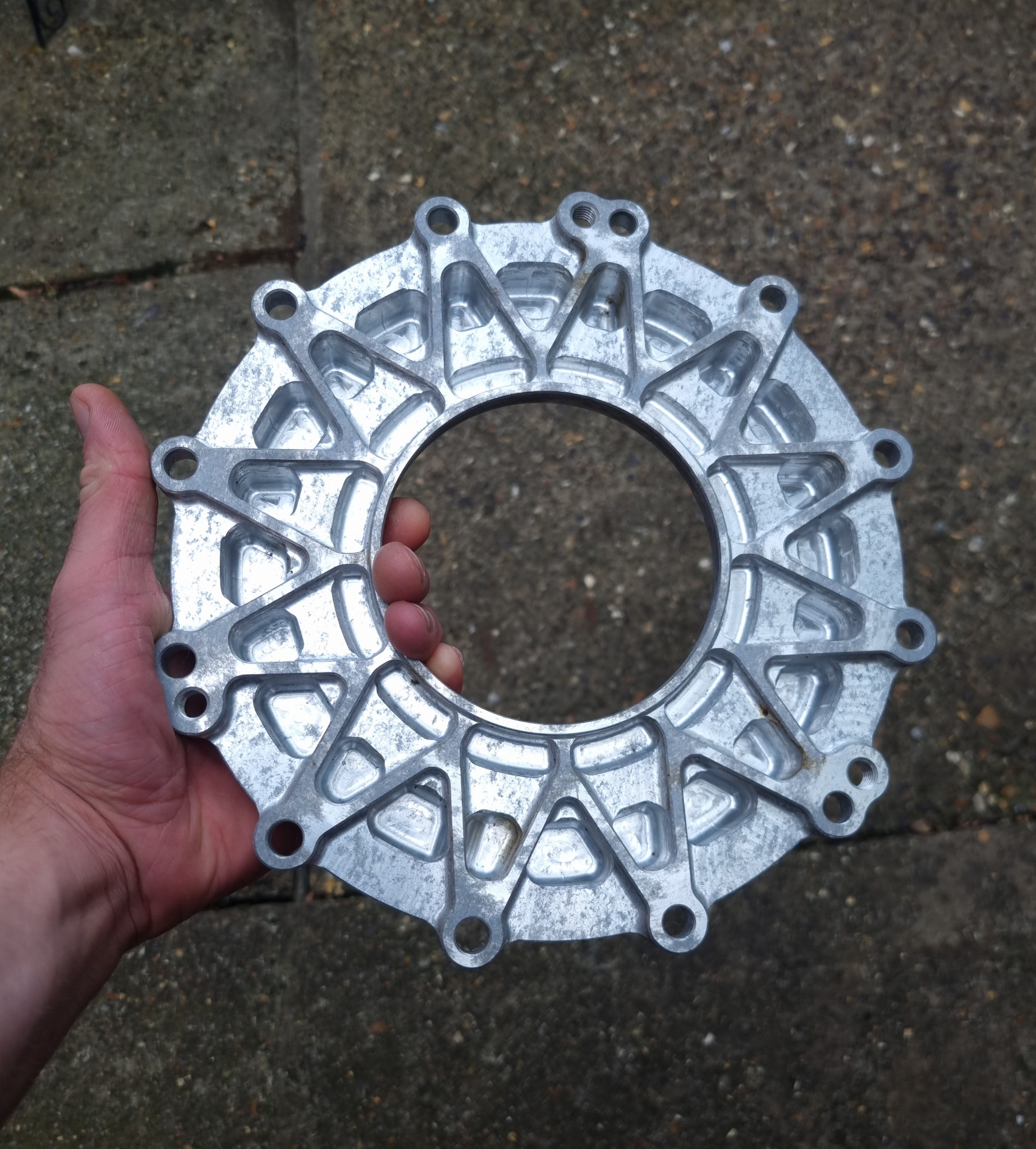 Large circular machined aluminium component shown in hand